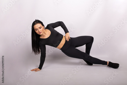Sport woman in sport style clothes on floor doing the exercise