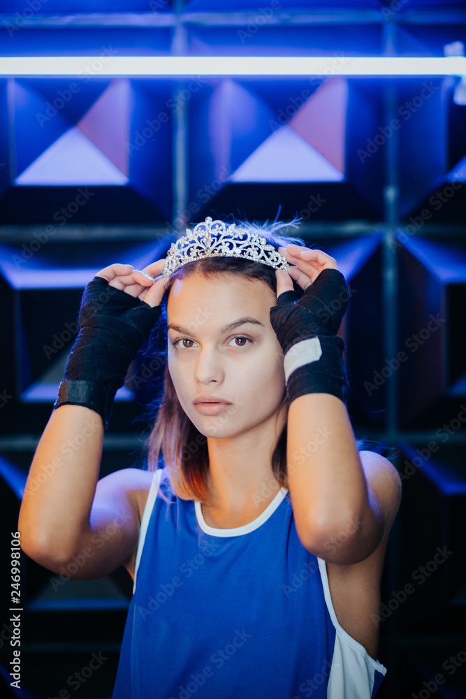 Female boxer at a boxing studio. Woman boxer training hard. Attractive Female Boxer At Training.Beautiful woman with the black boxing gloves. Girl is a champion