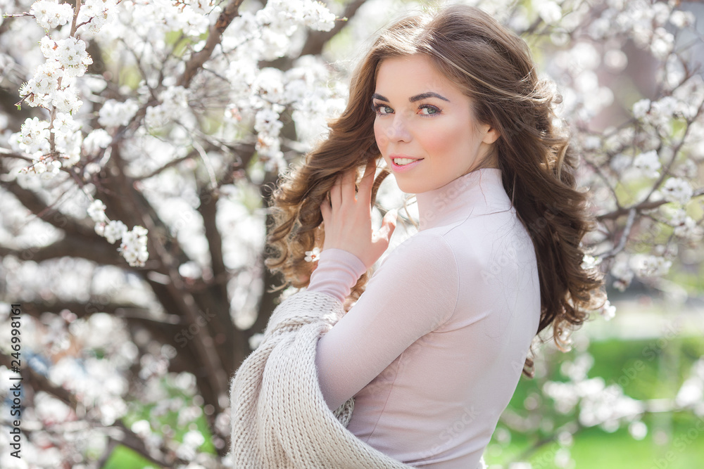 Long haired woman outdoors on spring background. Unrecognizable lady with flowers in hair. Curly haired female. Long haired woman outdoors on spring background. Unrecognizable lady with flowers in hair. Curly haired female.