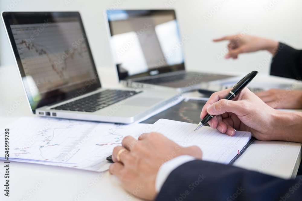 Naklejka premium Business Team trader or broker Investment Entrepreneur colleagues working discussing and analysis graph stock market trading with forex chart data, financial, selling and buying concept