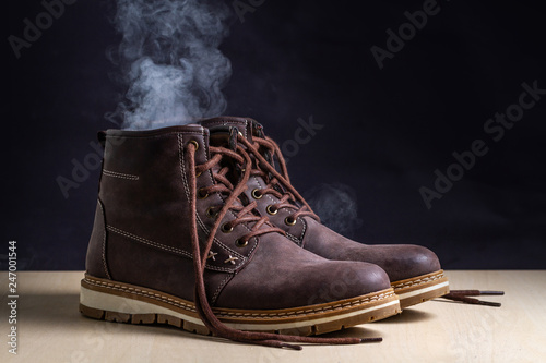Dirty boots with an unpleasant smell. Sweaty shoes after long walks and active lifestyle. Footwear needs in cleaning and odor removal. Shoe care and shine