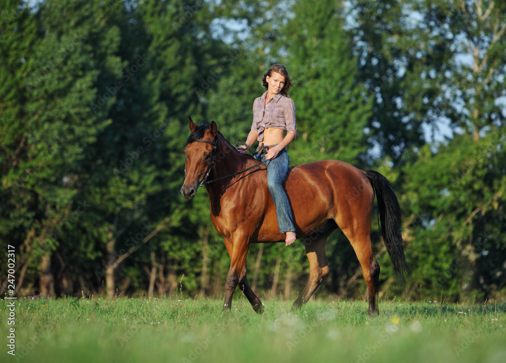 Beautiful cowgirl bareback ride her horse in woods glade at sunset Beautiful cowgirl bareback ride her horse in woods glade at sunset