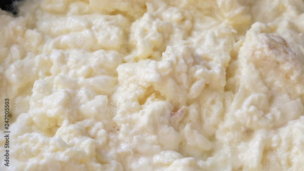 Cooking scrambled eggs on frying pan, macro Cooking scrambled eggs on frying pan, macro
