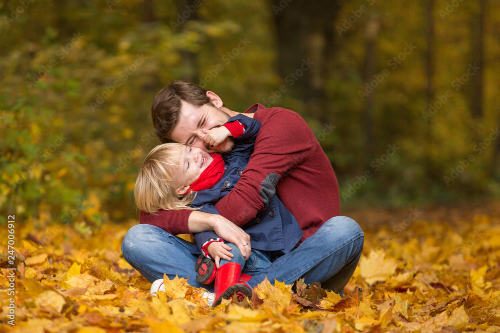 Father and daughter hug and laugh in the autumn park. Father and daughter hug and laugh in the autumn park.