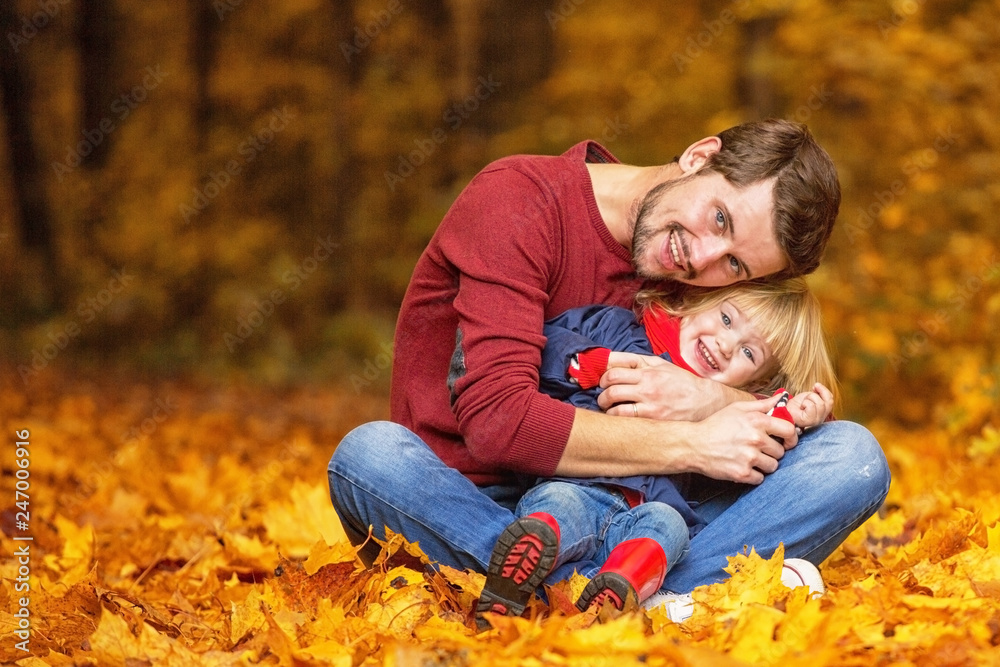 Father and daughter hug and laugh in the autumn park. Father and daughter hug and laugh in the autumn park.