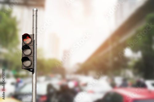 Traffic light with abstract blurred traffic jam background.