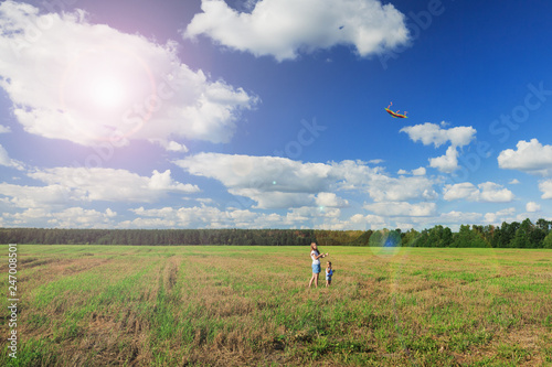 Mother and daughter flying a kite in a field