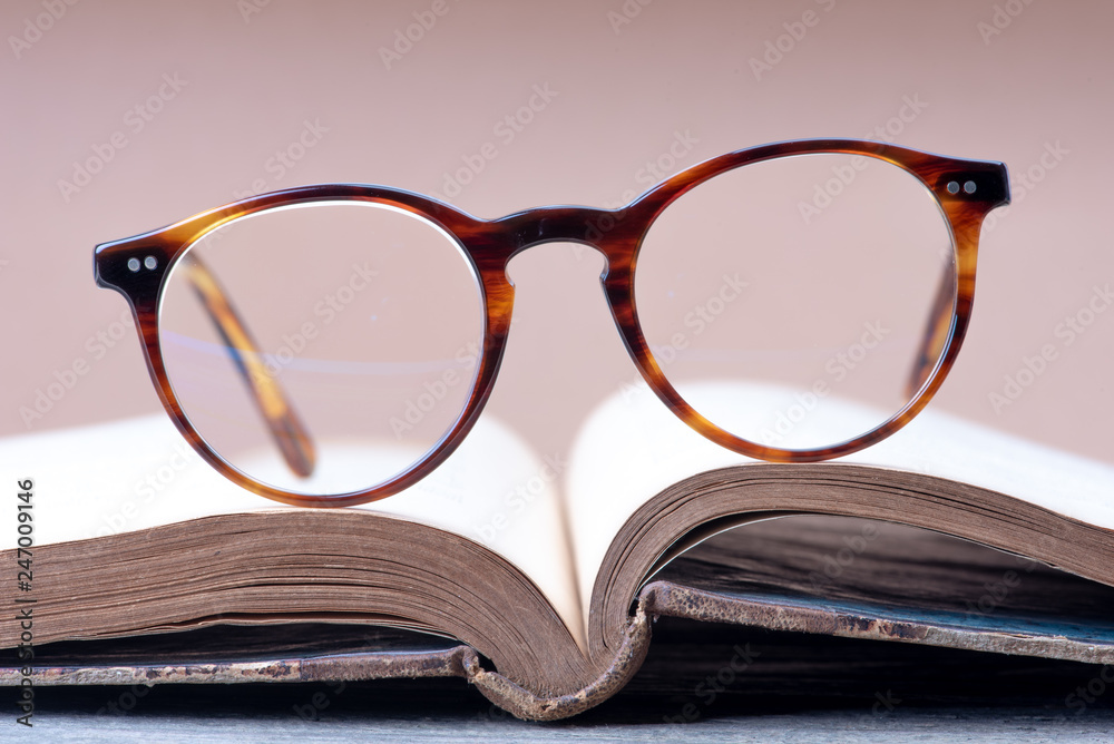 Opened book with reading glasses close-up Opened book with reading glasses close-up
