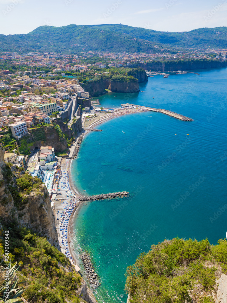 Aerial view of cliff coastline Sorrento and Gulf of Naples in Italy. Sunny summer day with blue sky, clear sea and green mountains of Sorrento Peninsula. Aerial view of cliff coastline Sorrento and Gulf of Naples in Italy. Sunny summer day with blue sky, clear sea and green mountains of Sorrento Peninsula.