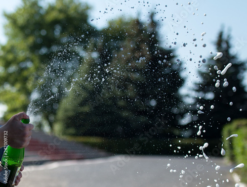 champagne splatters coming out of the bottle.