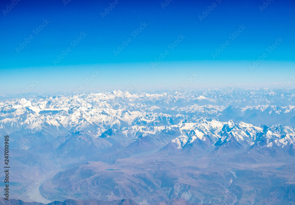 Obraz premium Mountains earth from aircraft under blue sky