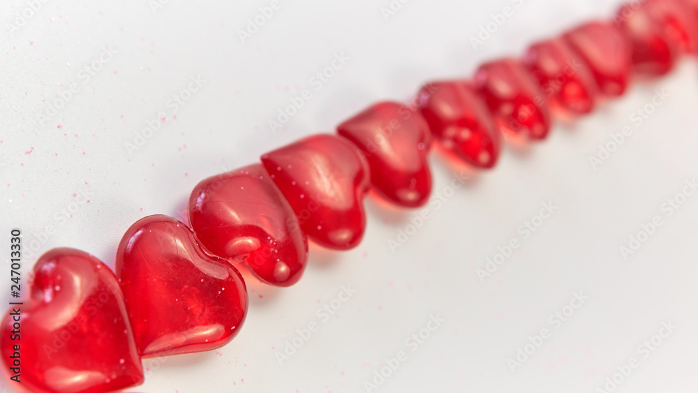 diagonal line from corner to corner of the small red hearts on a white background. Valentine's Day. love symbol. copy space. greeting card