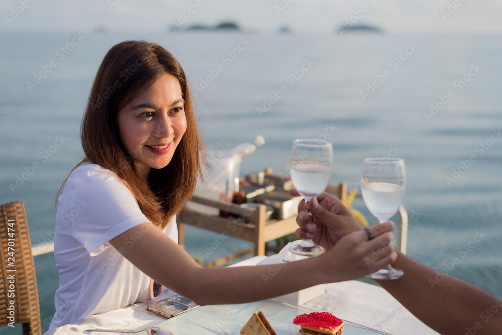 Φωτογραφία Lifestyle series: Asian woman holding glass of water, having dinner on boat