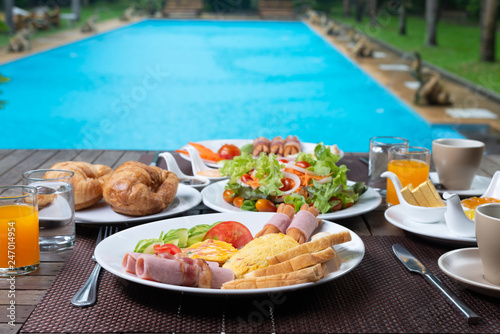 Food series  American breakfast set on wooden table by the pool