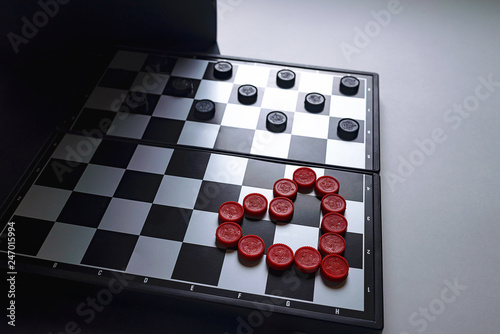 Chess Board lined with red checkers in the form of a heart. Valentine's day card concept. Heart on Valentine's day background