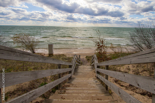 Fototapeta Naklejka Na Ścianę i Meble -  Wooden Stairs To Beach. Long wooden staircase leads to a sunny sandy beach on the Michigan coast of Lake Michigan.