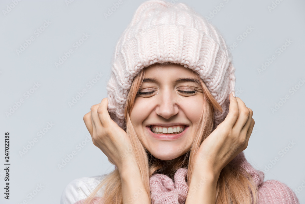 Close up studio portrait of attractive joyfully smiling girl in pink sweater and white hat, dressed casually/ good-looking beautiful woman, positive emotions after receiving pleasant compliment. Close up studio portrait of attractive joyfully smiling girl in pink sweater and white hat, dressed casually/ good-looking beautiful woman, positive emotions after receiving pleasant compliment.