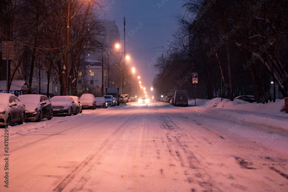 city road covered with snow with cars on the sidelines in winter season b