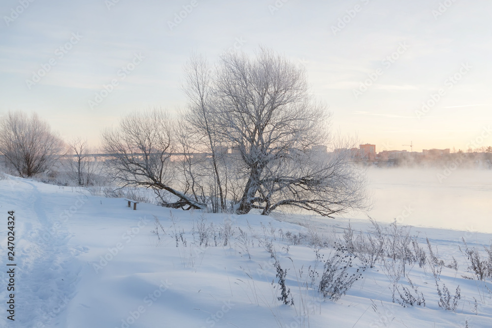 Winter landscape in the early morning overlooking the city of Dubna and the bridge over the Volga. Frosty fog obscures the banks of the river. The tops of the trees are covered with hoarfrost. Winter landscape in the early morning overlooking the city of Dubna and the bridge over the Volga. Frosty fog obscures the banks of the river. The tops of the trees are covered with hoarfrost.