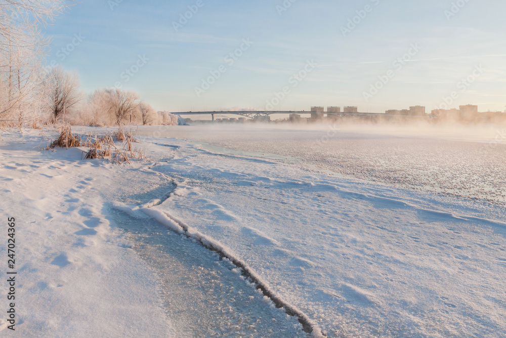 Winter landscape in the early morning overlooking the city of Dubna and the bridge over the Volga. Frosty fog obscures the banks of the river. The tops of the trees are covered with hoarfrost. Winter landscape in the early morning overlooking the city of Dubna and the bridge over the Volga. Frosty fog obscures the banks of the river. The tops of the trees are covered with hoarfrost.