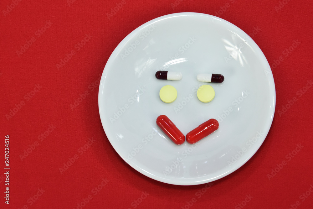 Happy face made of medicine. pain medication tablets. colored pills on porcelain dish. Assorted pharmaceutical pills. Happy face made of medicine. pain medication tablets. colored pills on porcelain dish. Assorted pharmaceutical pills.