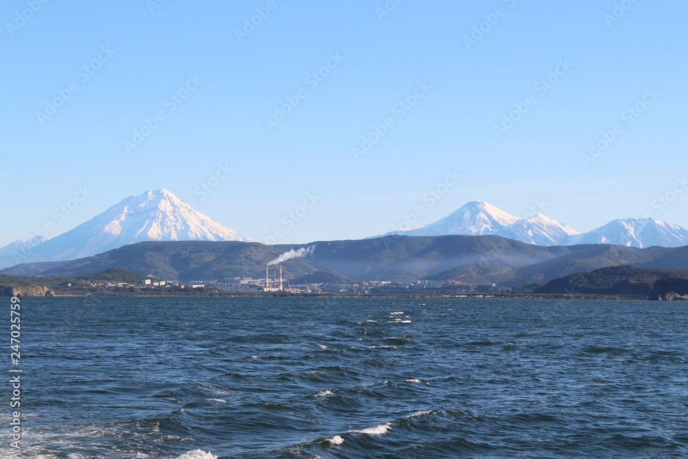 Avachinsky and Koryaksky volcanoes towers over the city of Petropavlovsk-Kamchatsky on the Kamchatka Peninsula, Russia.