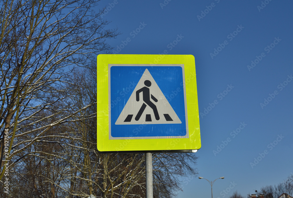 Pedestrian crossing road sign in blue sky Pedestrian crossing road sign in blue sky