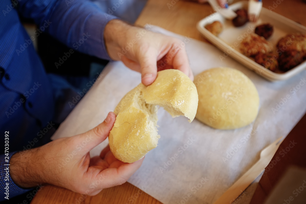 Man hands holding freshly baked soft bread roll. Fast food. Restaurant Man hands holding freshly baked soft bread roll. Fast food. Restaurant