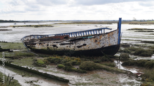 Derelict wooden boats beached on mud flat