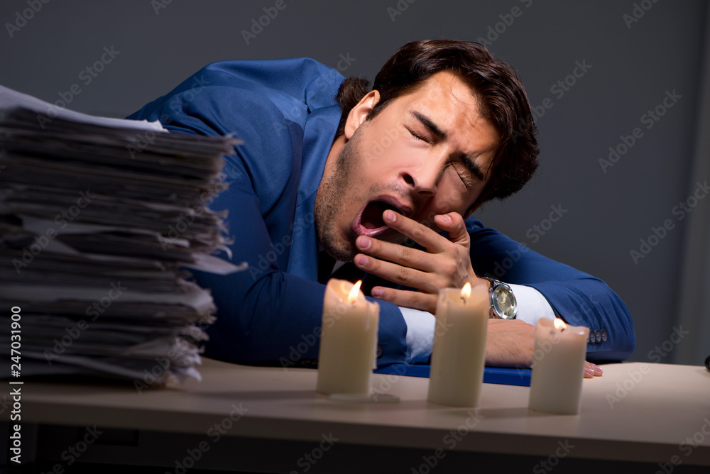 Obraz premium Businessman working late in office with candle light