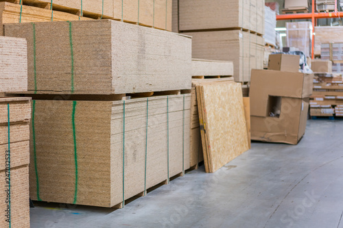 lumber osb, plywood, mdf, project panel at hardware store in USA. Wooden bars, flake board, sterlingboard on shelves inside lumber yard of home improvement retailer. Customer shopping.