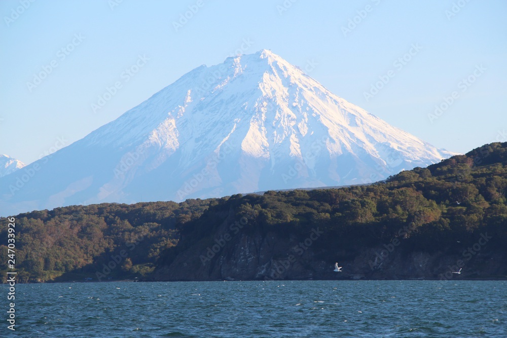 Koryaksky volcano rises above the coastline of the Kamchatka Peninsula. Koryaksky or Koryakskaya Sopka is an active volcano on the Kamchatka Peninsula in the Russian Far East.