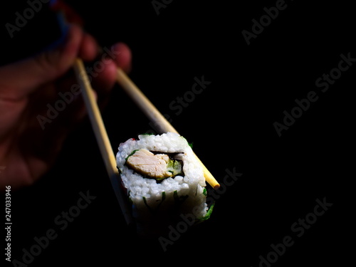 Japanese food. Minimalism. Food Photos. Pieces of sushi with wooden chopsticks.