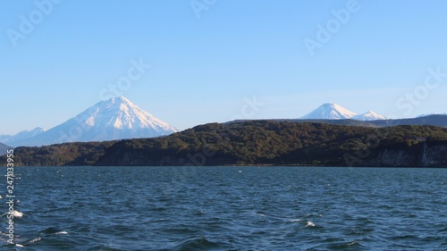Avachinsky and Koryaksky volcanoes rises above the coastline of the Kamchatka Peninsula.