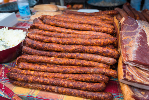 traditional smoked pork sausages lined up next to each other at the village fair