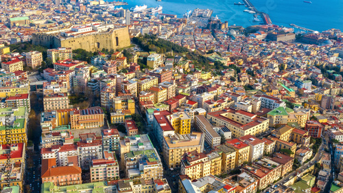 Aerial view of Naples from the Vomero district. You can see Castel Sant'elmo in the foreground while in the background the city's port and the Ovo castle. There are houses and buildings.
