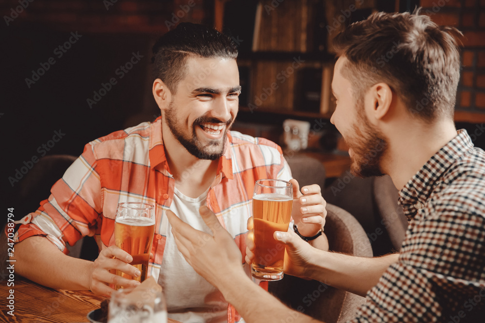 Happy friends met bar with glass of beer, joking, having fun. Concept sports pub