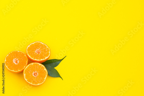 Creative summer background. Sliced orange on a yellow background. Copy space.