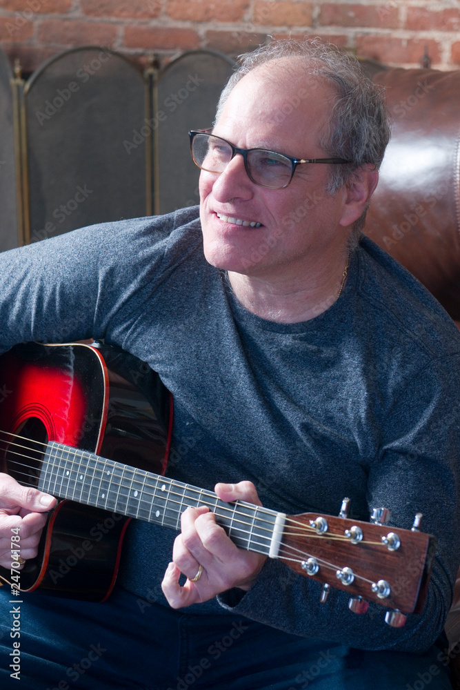 Obraz premium middle age senior man playing guitar