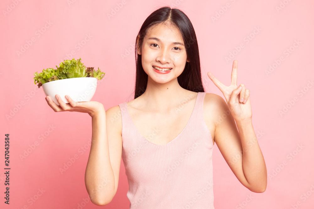 Healthy Asian woman show victory sign with salad. Healthy Asian woman show victory sign with salad.