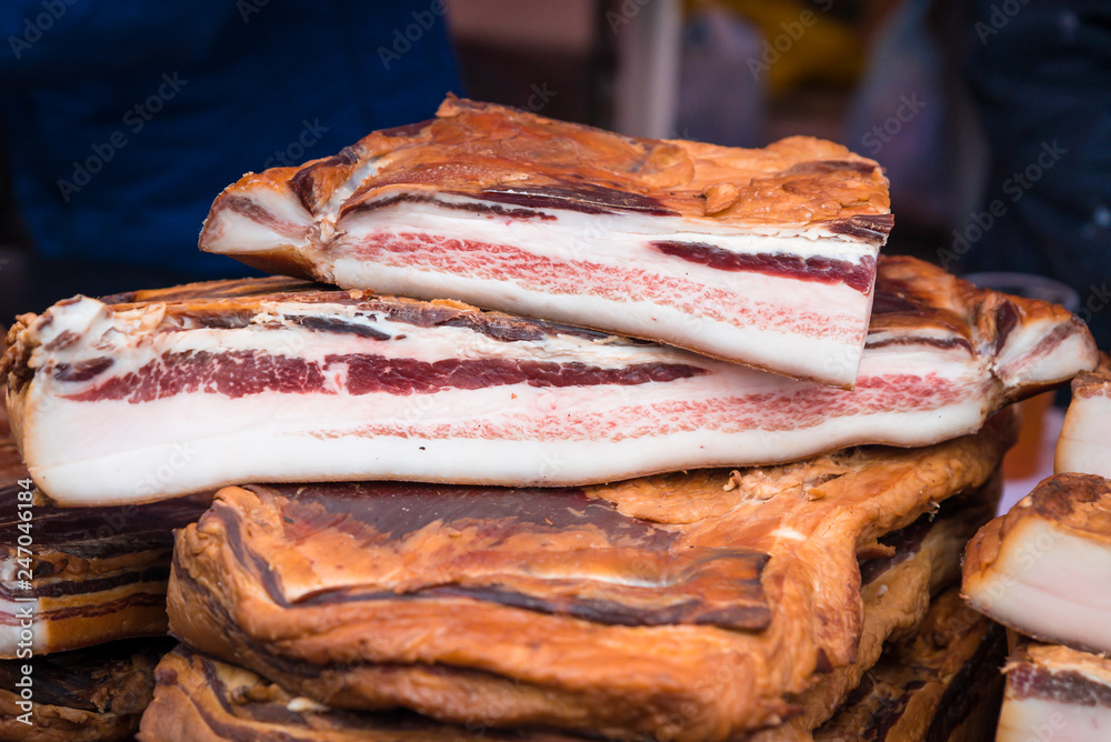 homemade smoked bacon arranged for sale in a village fair