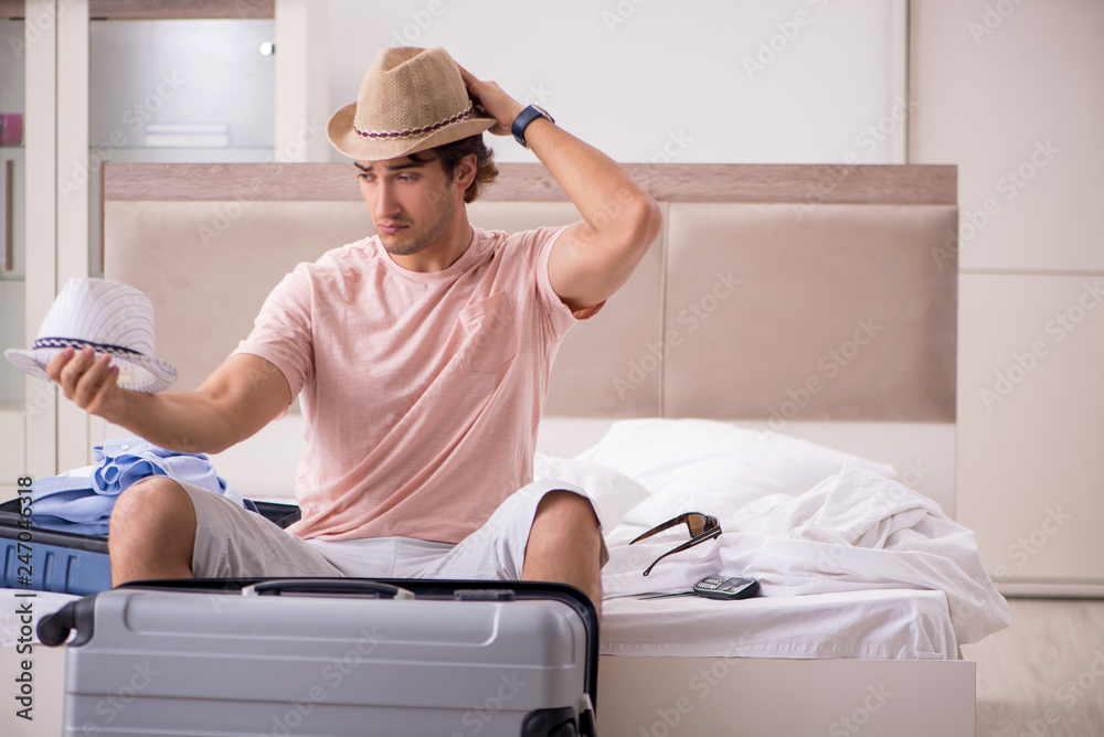 Man with suitcase in bedroom waiting for trip Man with suitcase in bedroom waiting for trip