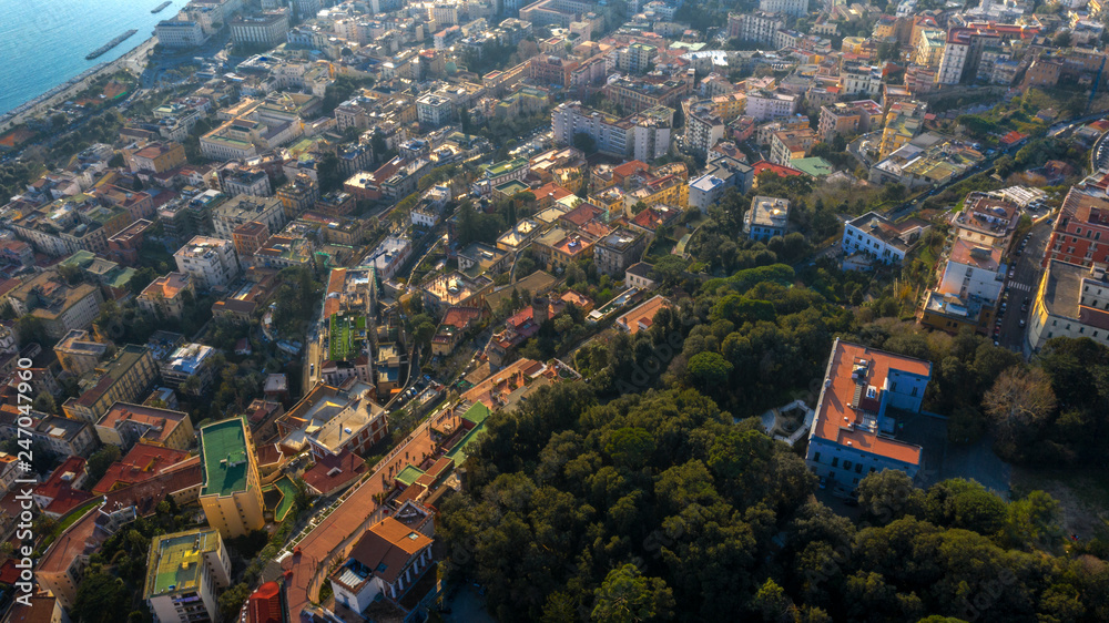 Aerial view of the waterfront of Naples, the Chiaia and Mergellina neighborhoods, from the Vomero hill. There are many houses and buildings in the narrow streets of the city.