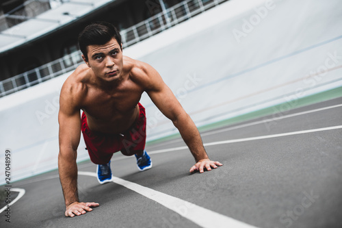 Concentrated male with attractive body making workout