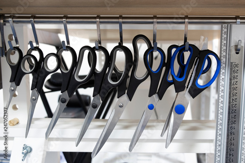 Scissors and rulers hang on hooks. Office concept in details