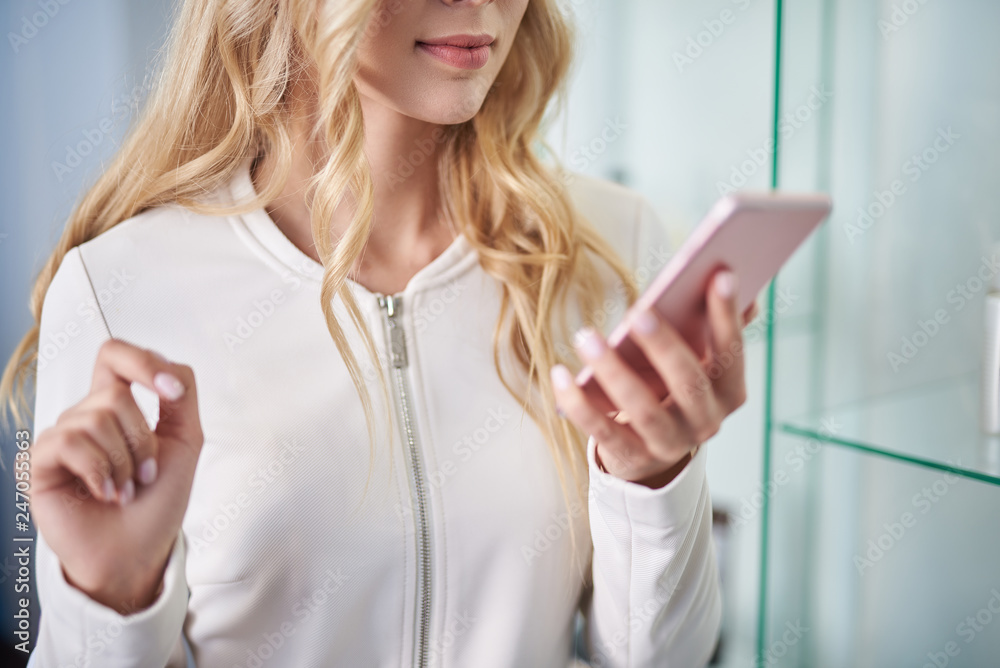 Charming young woman is using modern smartphone Charming young woman is using modern smartphone