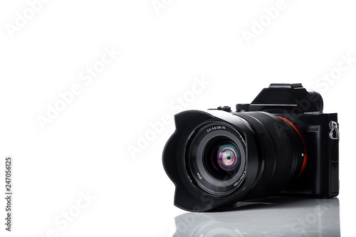mirrorless digital camera with telephoto zoom lens isolated on white background with reflections on the lens photo