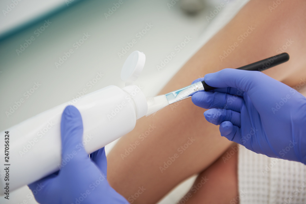 Highly qualified aesthetician preparing gel for laser hair removal treatment Highly qualified aesthetician preparing gel for laser hair removal treatment
