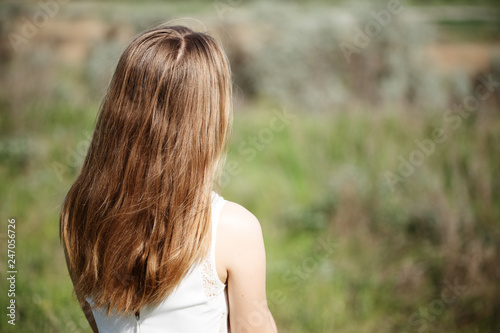 girl standing with her back in the field