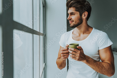 Young guy enjoy hot drink in morning
